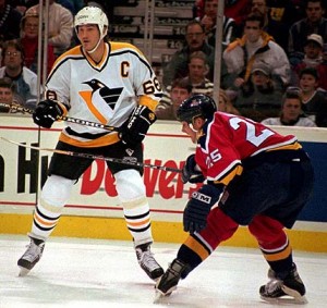 Pittsburgh Penguins Mario Lemieux (66) looks for the puck as Florida Panthers Geoff Smith (25) guards him in the first period of the game in Pittsburgh Saturday, Dec. 30, 1995. Lemieux scored two goals in the first period. (AP Photo/Keith Srakocic)